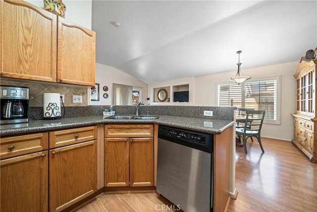 kitchen with sink, vaulted ceiling, light hardwood / wood-style flooring, stainless steel dishwasher, and backsplash