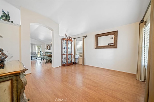 unfurnished living room with vaulted ceiling and light hardwood / wood-style flooring