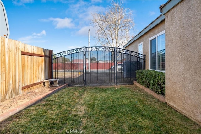 view of gate with a yard