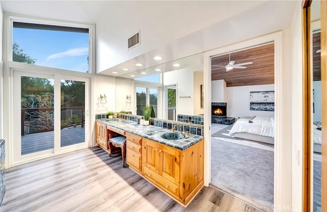 23216 Park Esperanza, Calabasas, CA 91302 - full bath with a lit fireplace, wood finished floors, double vanity, a high ceiling, and ceiling fan