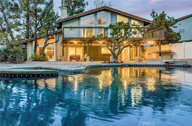 23216 Park Esperanza, Calabasas, CA 91302 - rear view of house featuring a balcony, a patio area, a chimney, a pool with connected hot tub, and fence