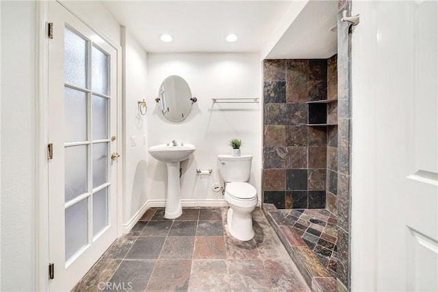 23216 Park Esperanza, Calabasas, CA 91302 - full bath with stone tile floors, toilet, baseboards, a tile shower, and a sink