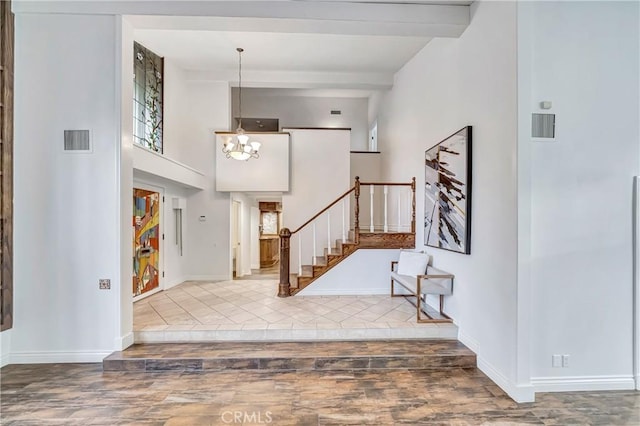 23216 Park Esperanza, Calabasas, CA 91302 - entryway featuring stairway, beamed ceiling, a chandelier, wood finished floors, and baseboards