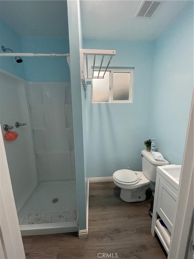 bathroom with vanity, hardwood / wood-style flooring, toilet, and a shower