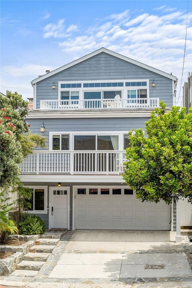 view of front of property with driveway, an attached garage, and a balcony