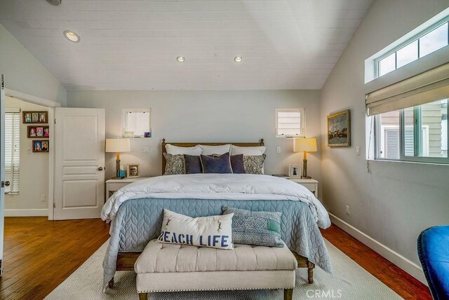 bedroom with multiple windows, wood finished floors, and vaulted ceiling