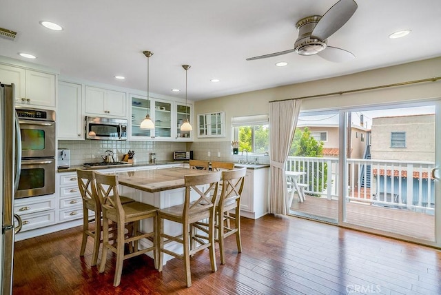 kitchen featuring white cabinetry, dark wood-type flooring, tasteful backsplash, and appliances with stainless steel finishes