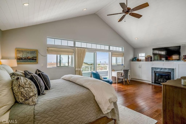 bedroom featuring access to exterior, high vaulted ceiling, dark hardwood / wood-style floors, ceiling fan, and a premium fireplace