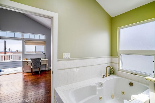 bathroom with lofted ceiling, wood finished floors, and a tub with jets