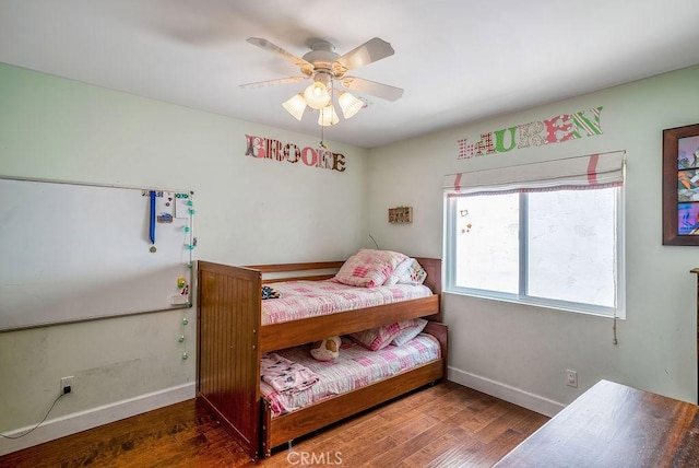 bedroom with ceiling fan, baseboards, and wood finished floors