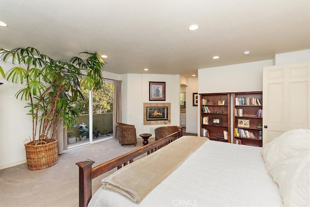 bedroom featuring access to exterior, carpet flooring, and a tile fireplace