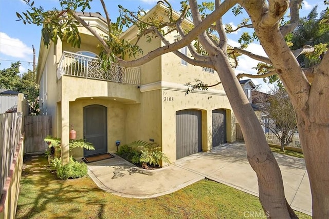 view of front facade with a garage, a front lawn, and a balcony