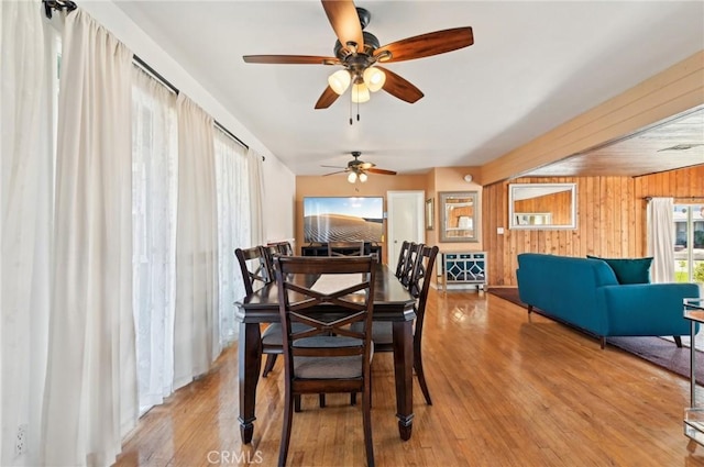 dining space featuring wood walls and wood finished floors