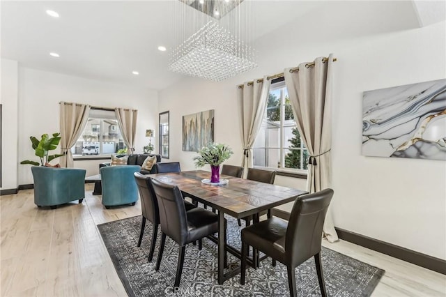 dining space featuring light hardwood / wood-style floors and a chandelier