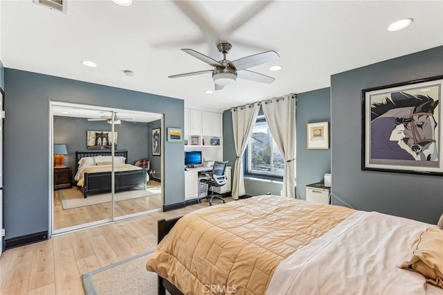 bedroom featuring built in desk, light hardwood / wood-style floors, and ceiling fan