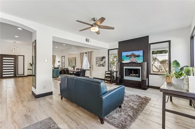 living room with ceiling fan and light wood-type flooring