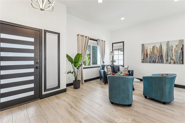 sitting room featuring a notable chandelier and light hardwood / wood-style floors