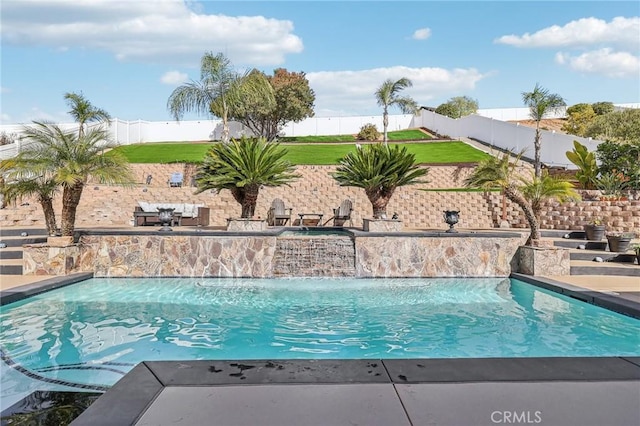 view of swimming pool with pool water feature and a lawn