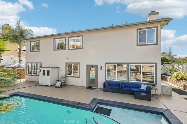 rear view of property with an outdoor living space and a patio