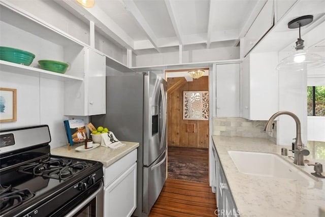 kitchen with a sink, light stone countertops, gas range, white cabinets, and dark wood-type flooring
