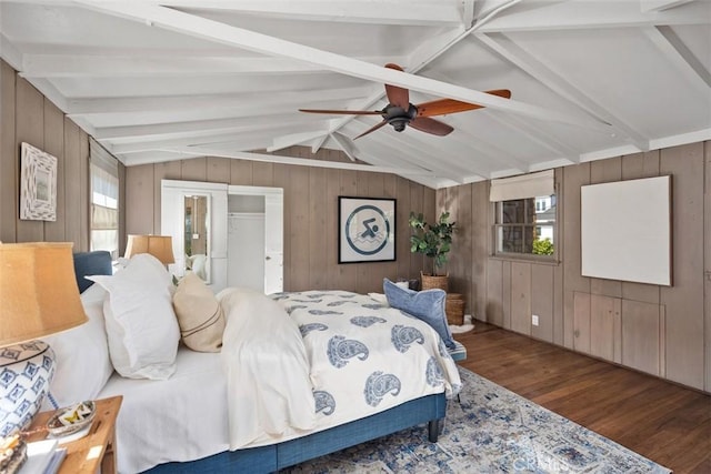 bedroom featuring vaulted ceiling with beams, wooden walls, ceiling fan, and wood finished floors