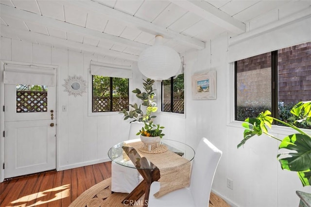 dining room with wood ceiling, wood finished floors, and beamed ceiling