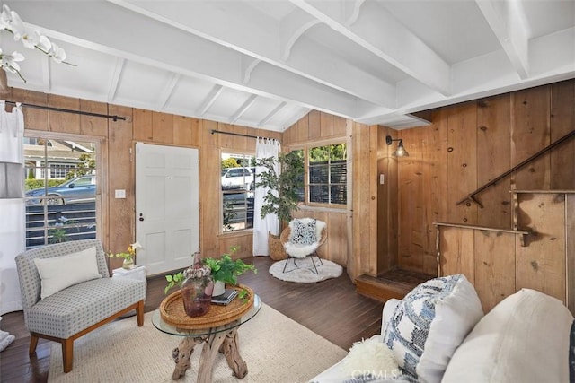 living area with lofted ceiling with beams, wood walls, and wood finished floors