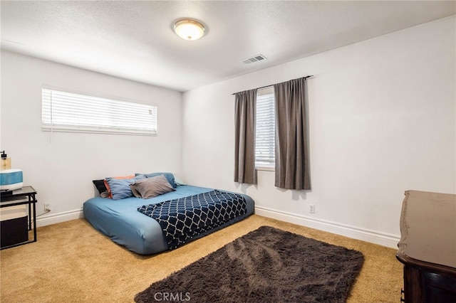 carpeted bedroom featuring a textured ceiling