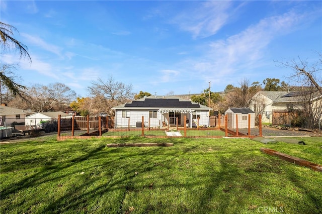 rear view of house with a storage shed and a lawn