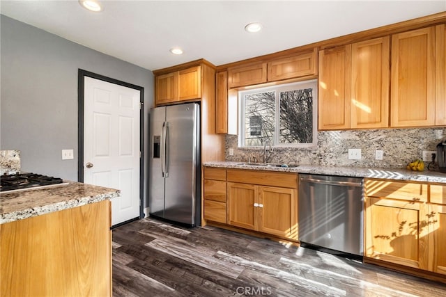 kitchen featuring a sink, appliances with stainless steel finishes, recessed lighting, backsplash, and light stone counters