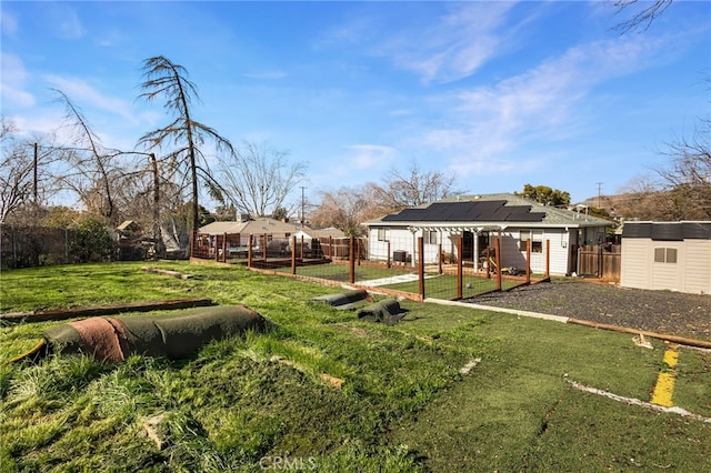 view of yard with a storage shed, a fenced backyard, and an outdoor structure