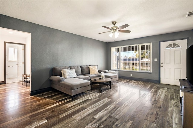 living room with ceiling fan, dark hardwood / wood-style floors, and a textured ceiling