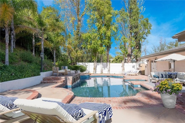 view of pool featuring a patio area, a pool with connected hot tub, fence, and outdoor lounge area