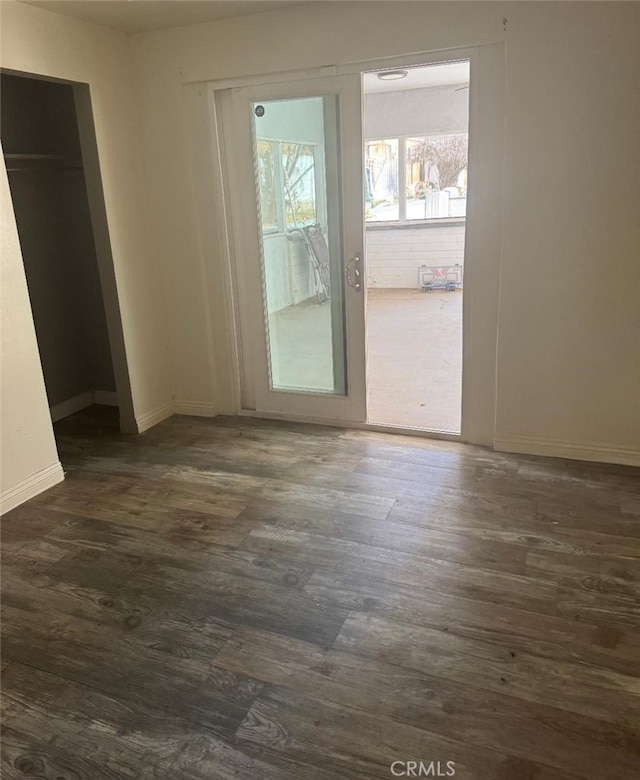 interior space featuring baseboards and dark wood finished floors