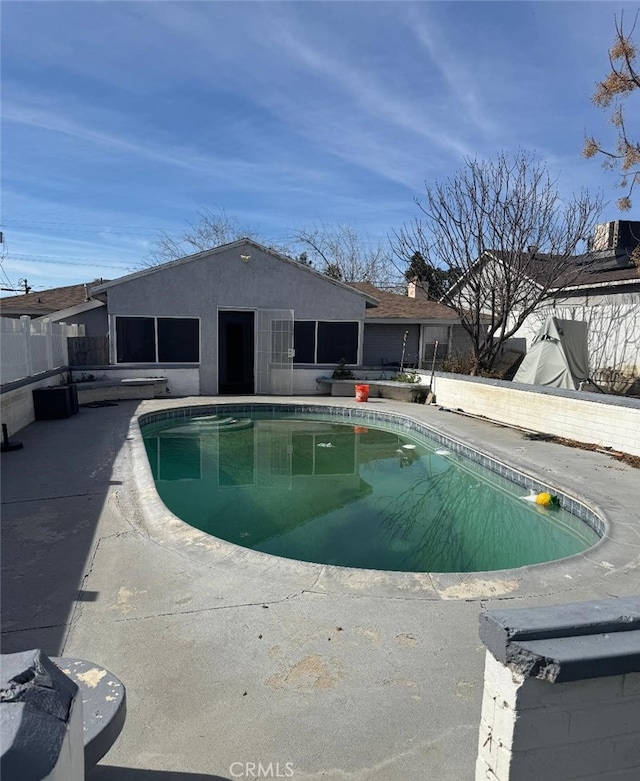 view of swimming pool featuring a patio, fence, and a fenced in pool