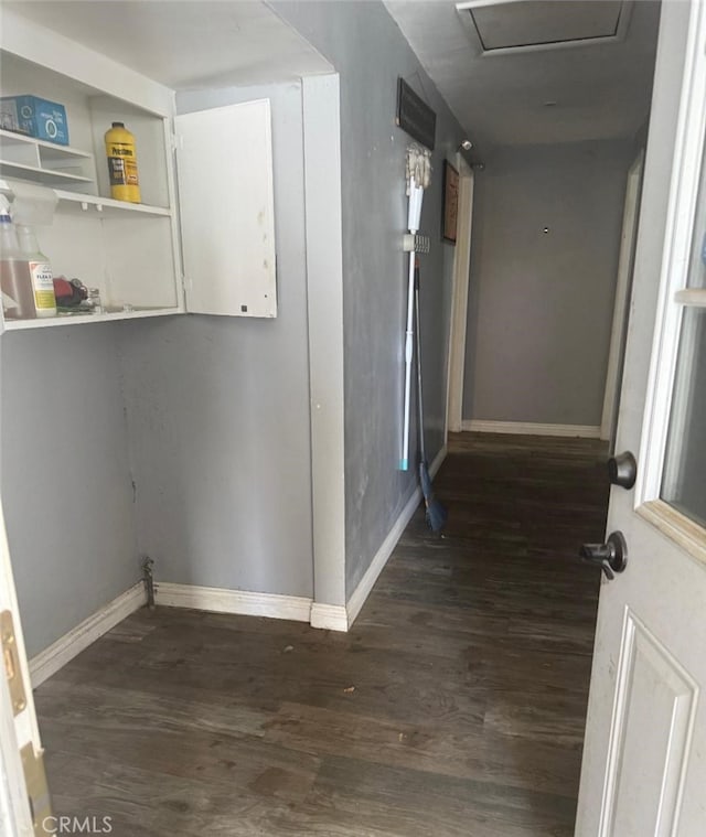 interior space featuring attic access, baseboards, and dark wood finished floors