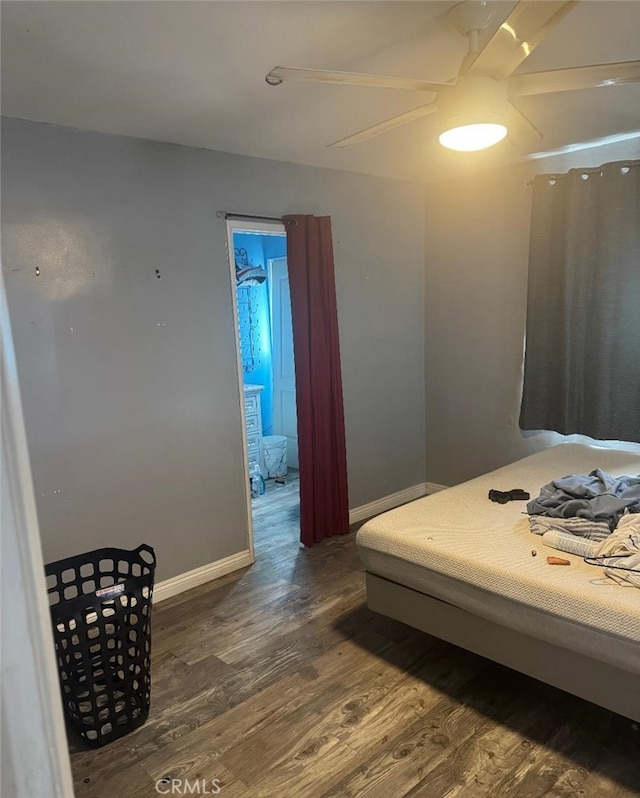 bedroom with ceiling fan, baseboards, and dark wood-type flooring