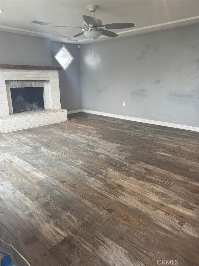 unfurnished living room featuring visible vents, a brick fireplace, ceiling fan, wood finished floors, and baseboards