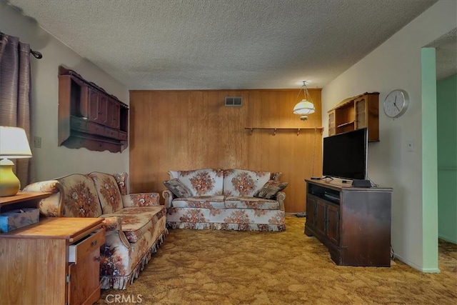 carpeted living room featuring a textured ceiling