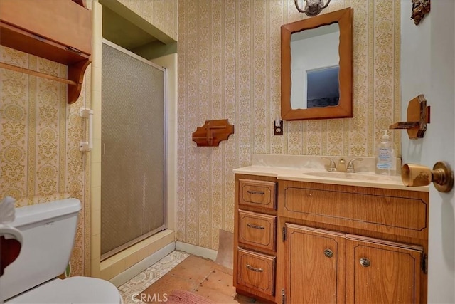 bathroom with vanity, toilet, an enclosed shower, and tile patterned flooring