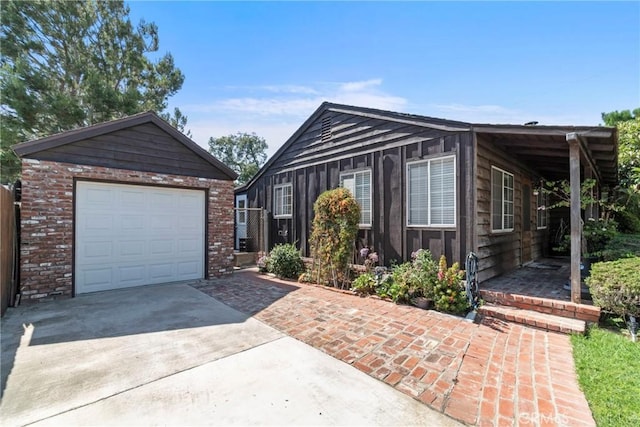 view of front facade with an outbuilding, concrete driveway, and brick siding