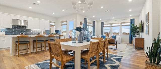 dining room with a healthy amount of sunlight and light hardwood / wood-style flooring