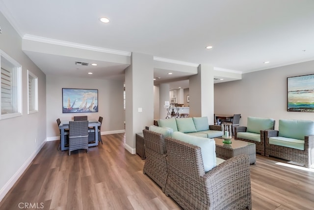 living room with ornamental molding and light hardwood / wood-style floors