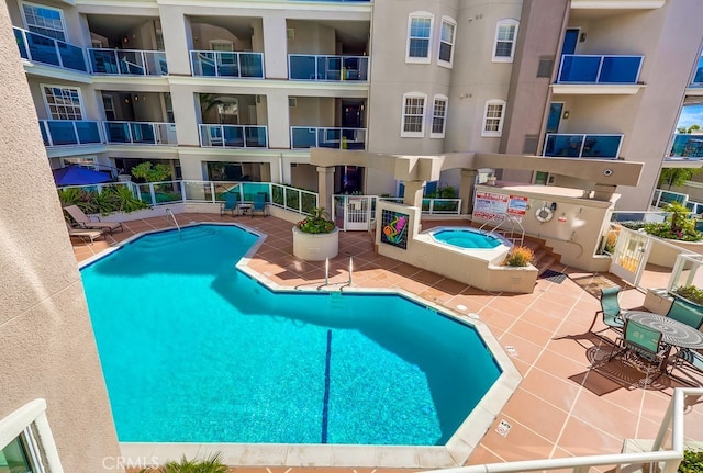 view of swimming pool featuring a community hot tub and a patio area