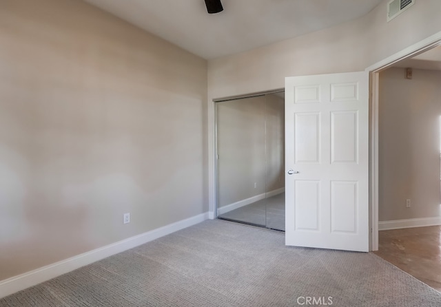 unfurnished bedroom with light carpet and a closet