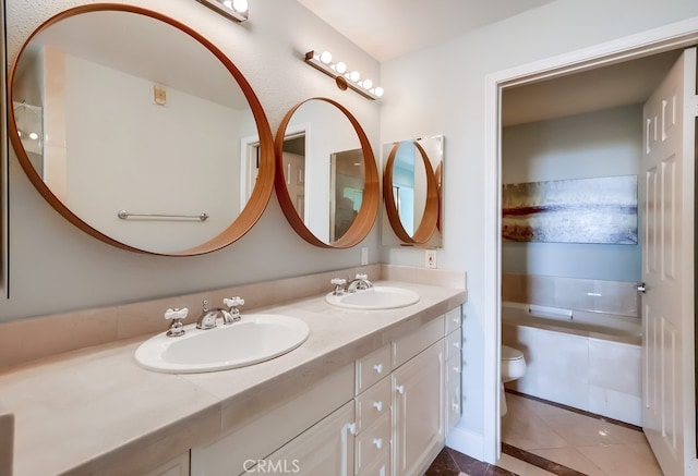 bathroom featuring tile patterned flooring, vanity, a bathing tub, and toilet