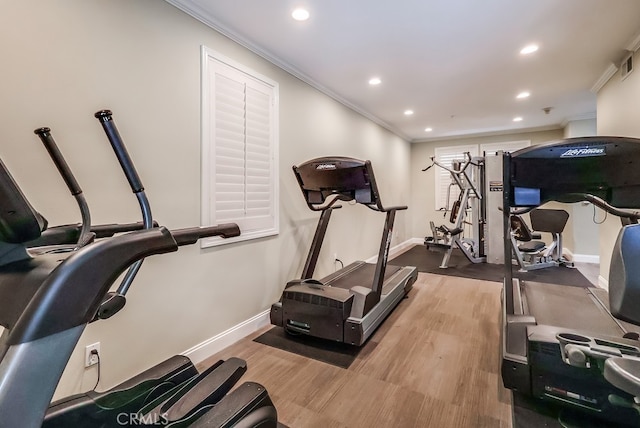 exercise area featuring crown molding and wood-type flooring