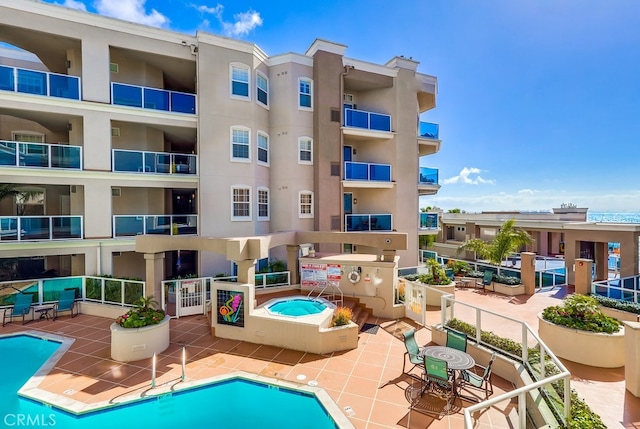 view of swimming pool with a hot tub and a patio area