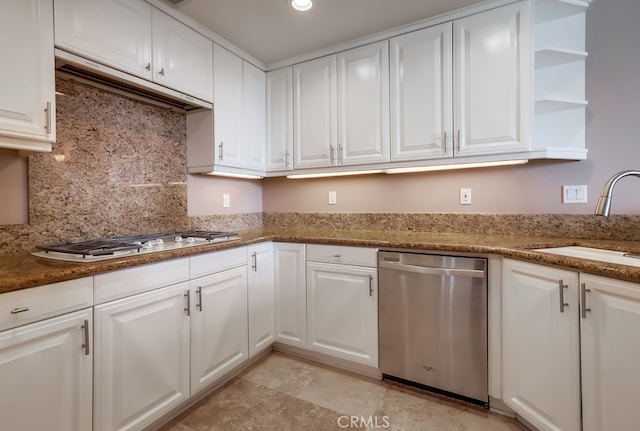 kitchen featuring sink, dark stone countertops, appliances with stainless steel finishes, white cabinets, and backsplash