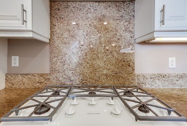 kitchen with gas stovetop, backsplash, and white cabinets